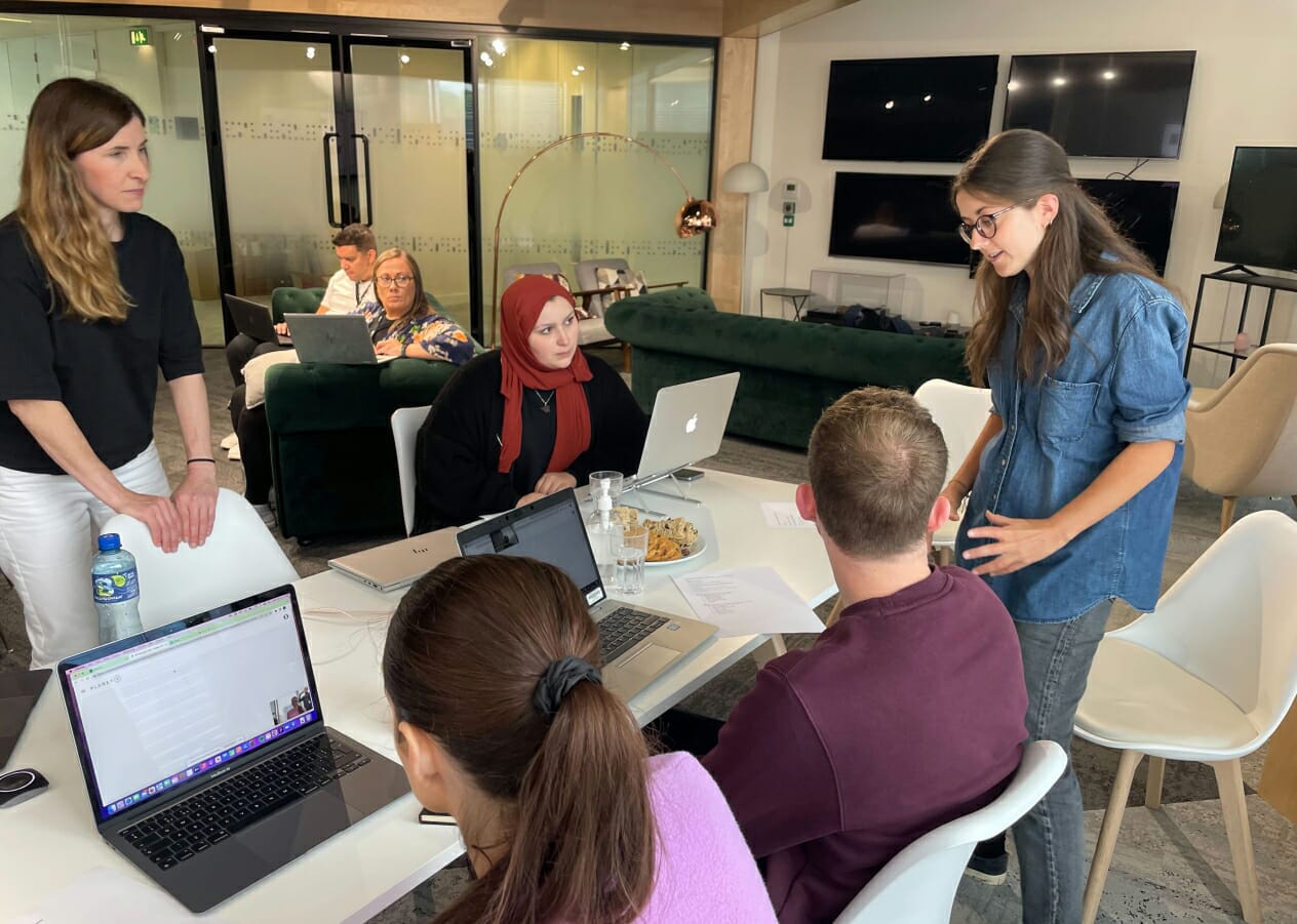 Qualitative UX research team around a table discussing ideas in a workshop